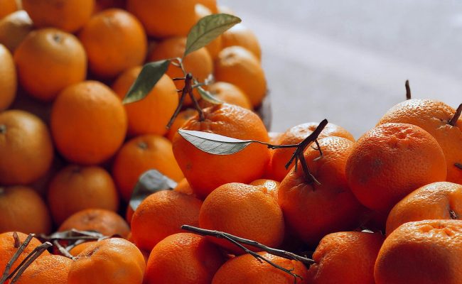 Vibrant display of fresh oranges and tangerines in natural light.
